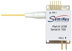 brass colored laser diode housing with electrical pins, fiber optic cable with connector and white label