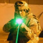 soldier aiming a weapon with a green diode laser attached